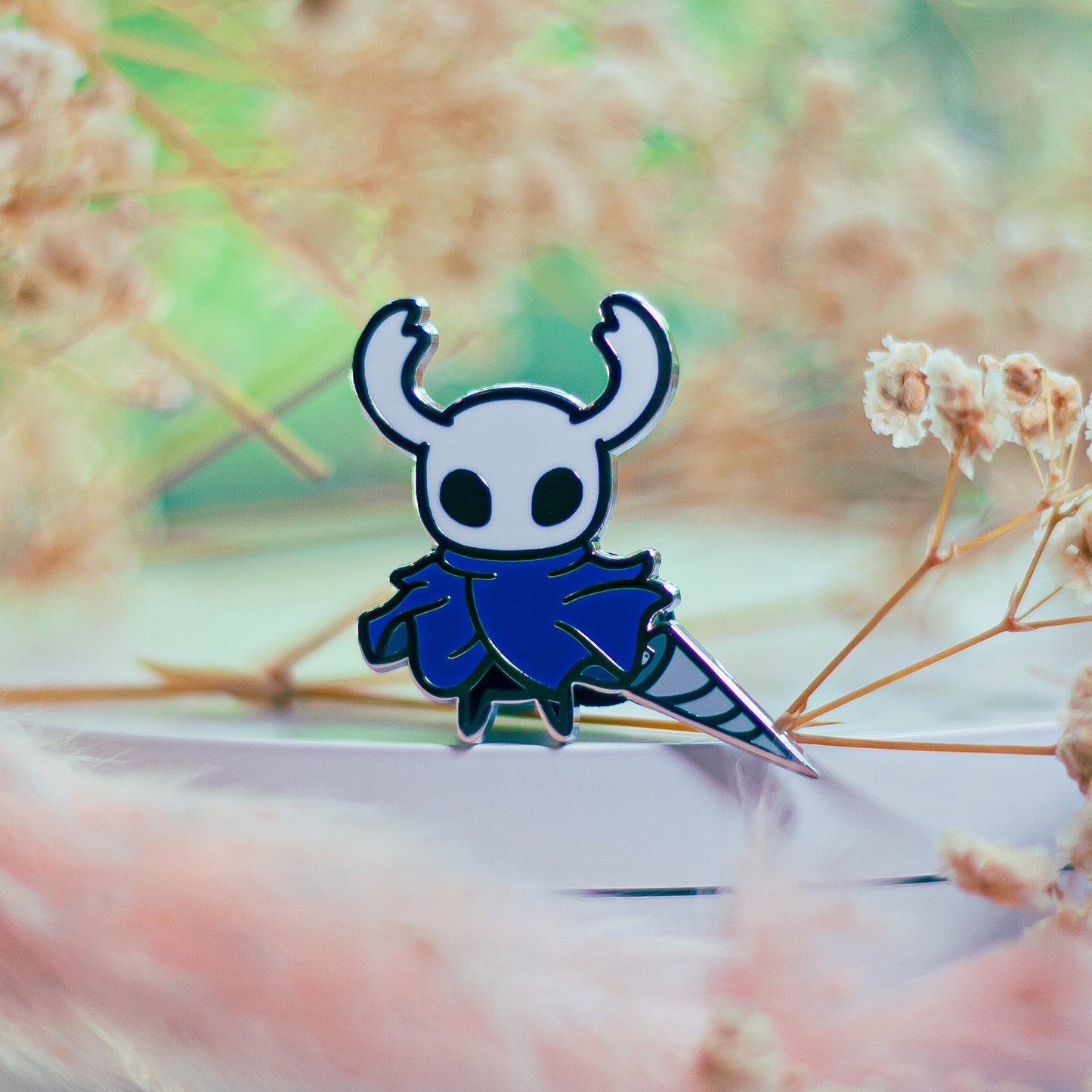 Cartoon character with blue cape on a blurred natural background