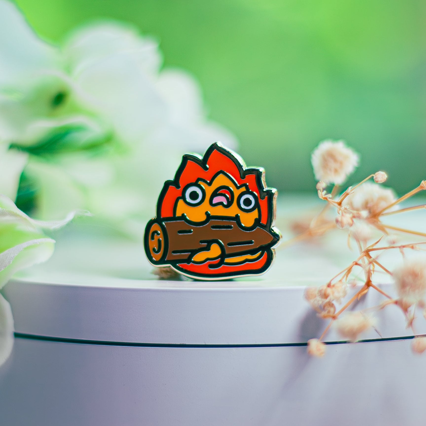 Cartoonish fire logo on a white surface with flowers in the background