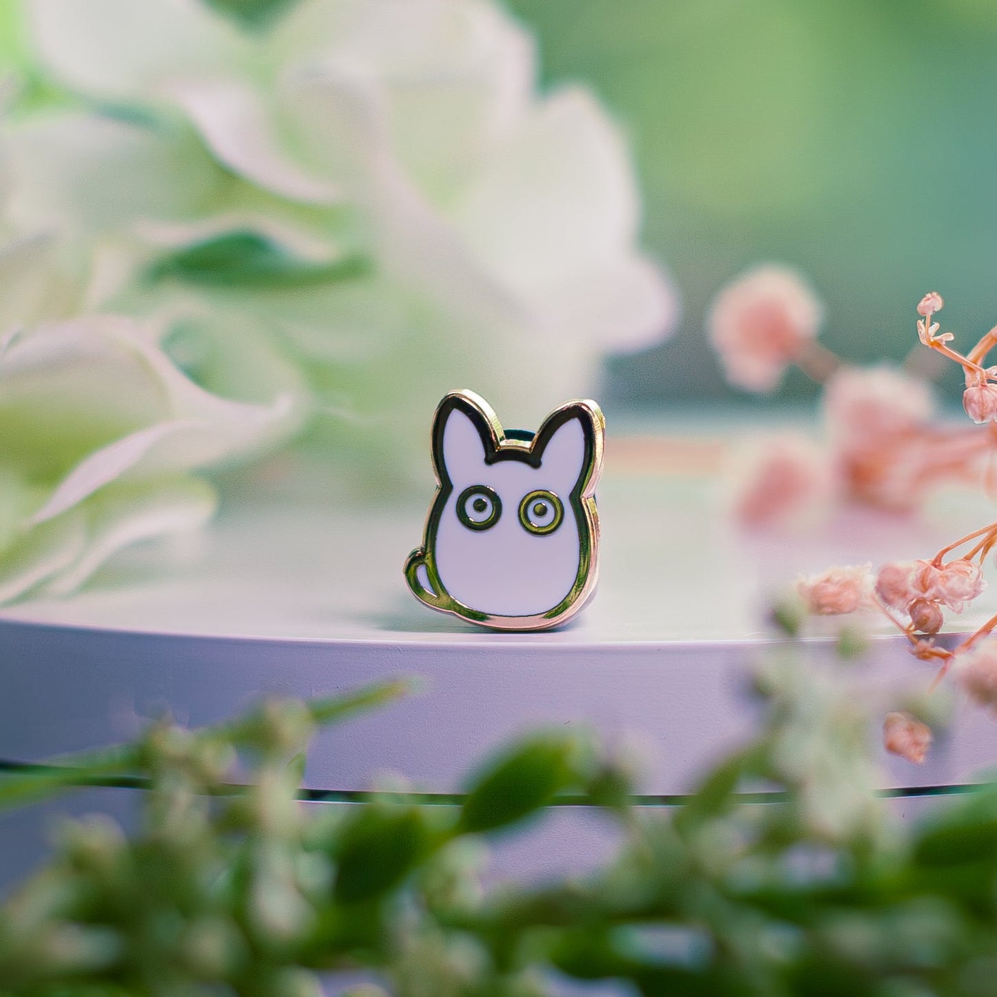 Cartoon character pin on a stand with flowers in the background