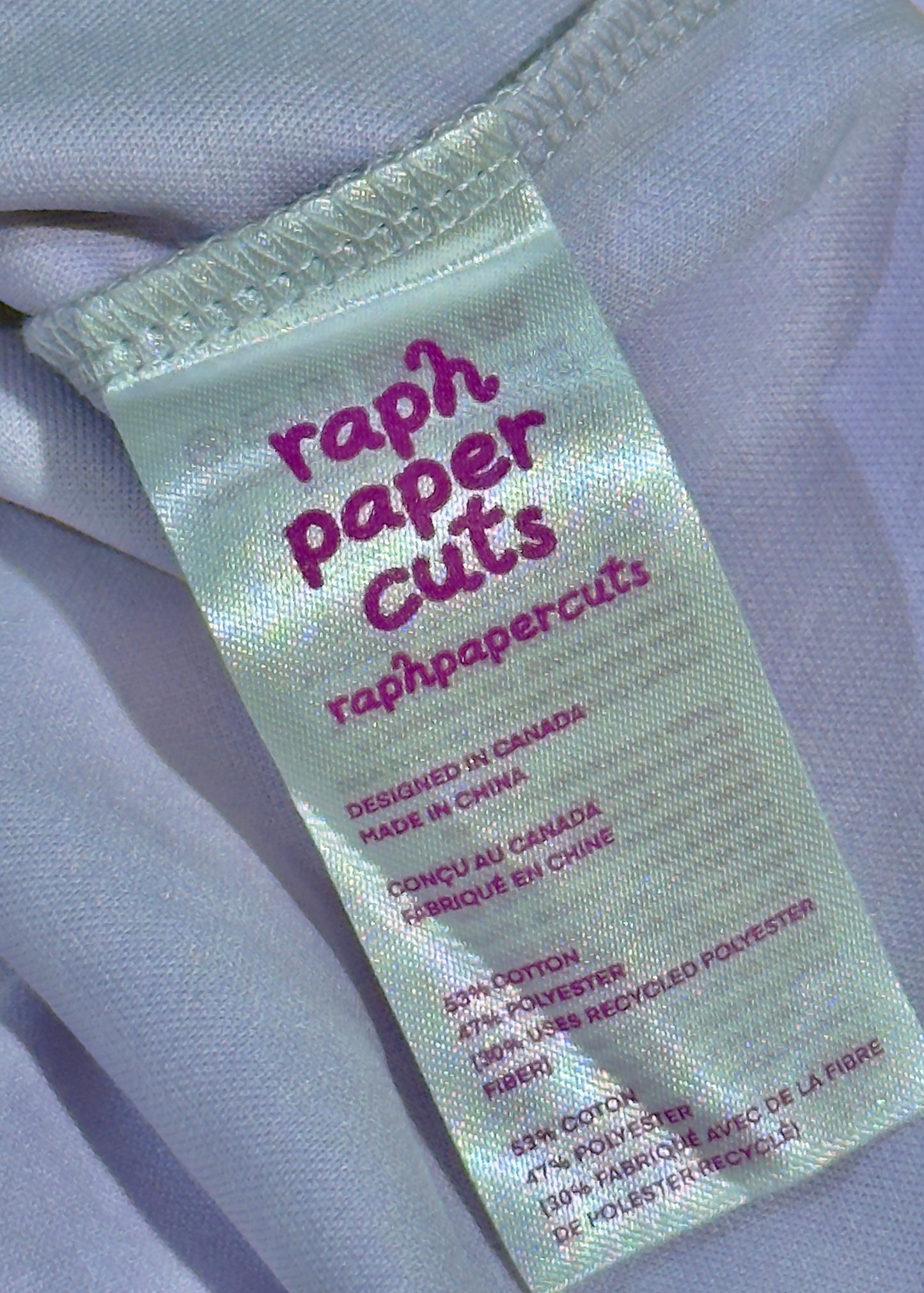 Label with 'raph paper cuts' text on a light fabric background