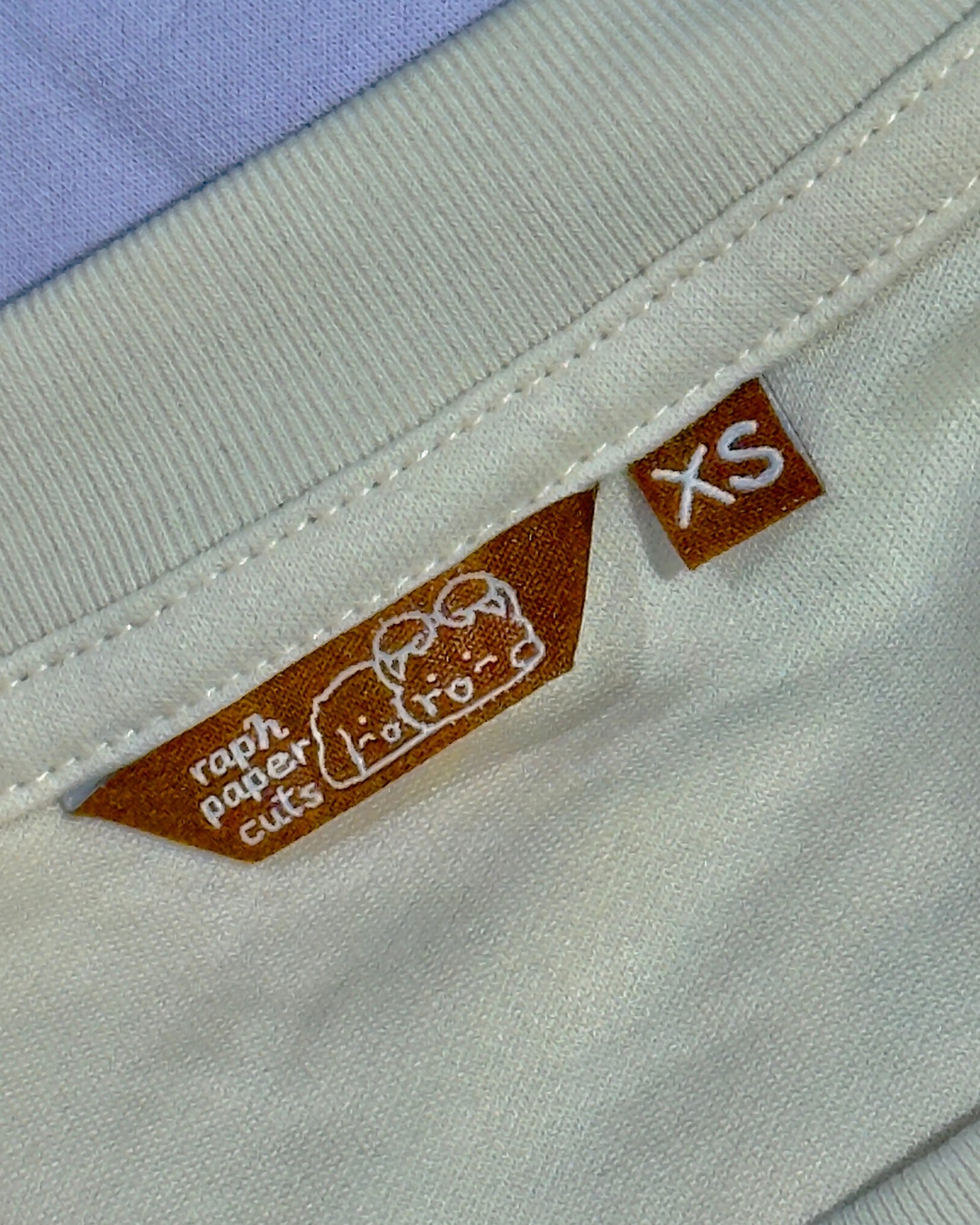 Close-up of a label on a garment with text and a logo.
