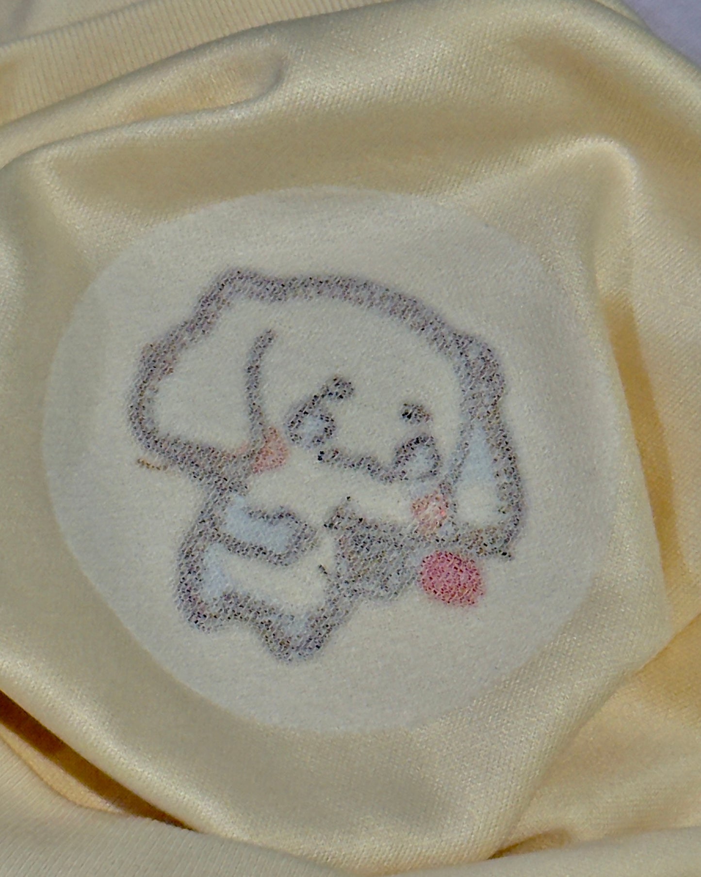 Embroidered elephant design on a beige fabric background